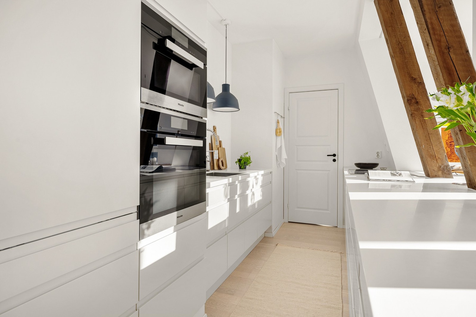 Kjøkkenet inneholder slette fronter og Corian benkeplate med underlimt vask av stål. Galleribilde