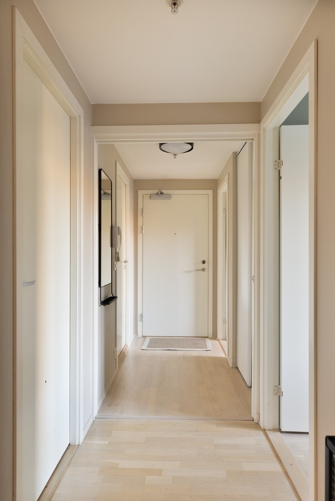 Her finner du en praktisk skyvedørsgarderobe som gir god plass til oppbevaring av yttertøy og sko, samt porttelefon som gjør det enkelt å slippe inn gjester. Galleribilde