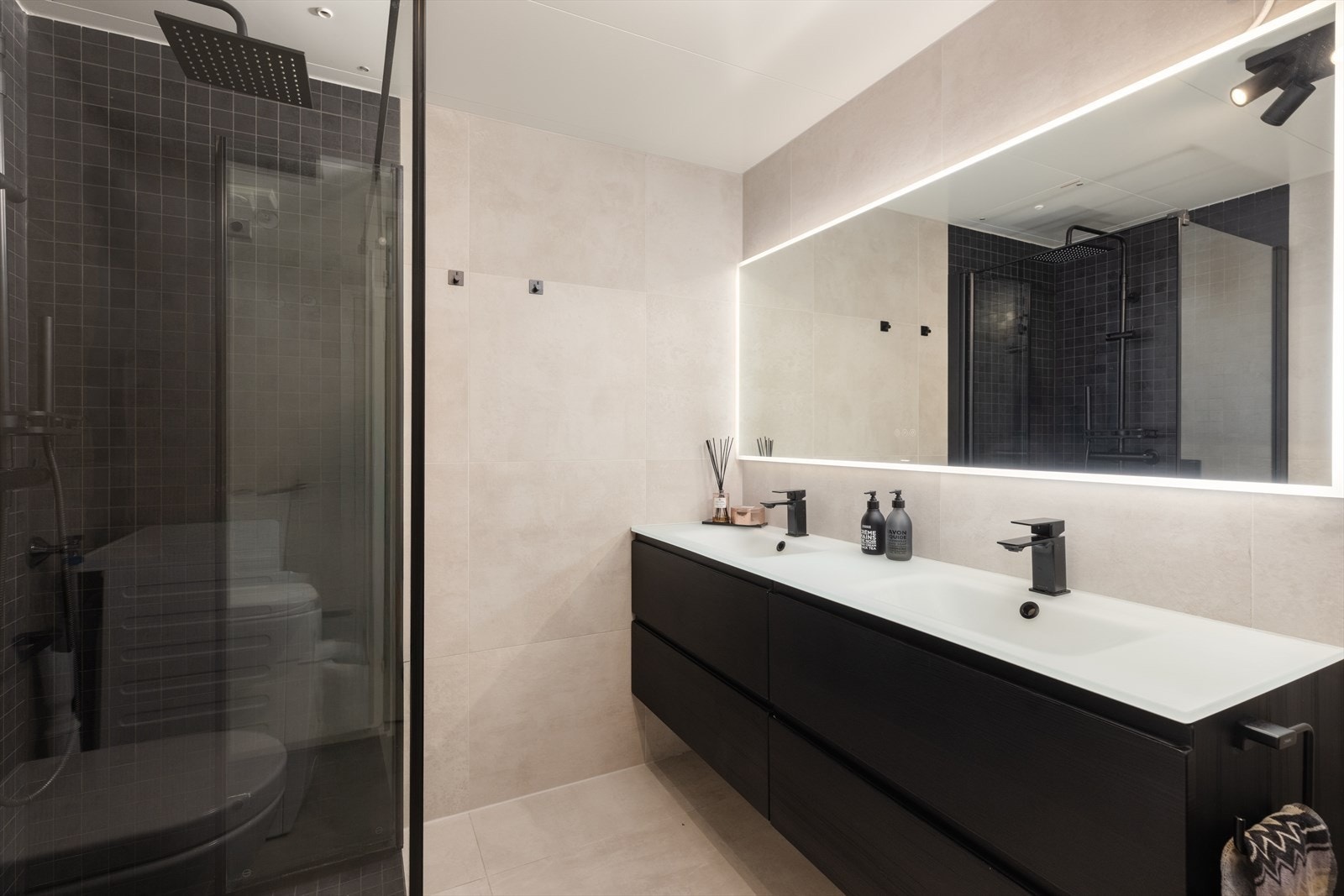 Badet er praktisk og funksjonelt, med flislagte gulv og vegger. Galleribilde