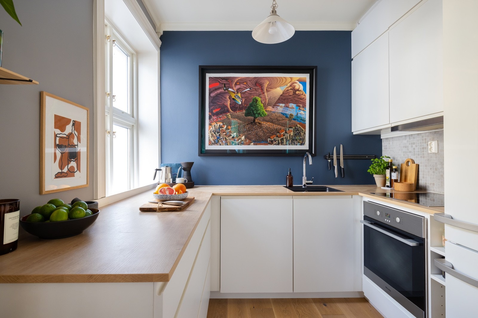 Moderne kjøkkeninnredning fra Kvik (2017) med pene fronter og belysning over laminat benkeplate. Galleribilde