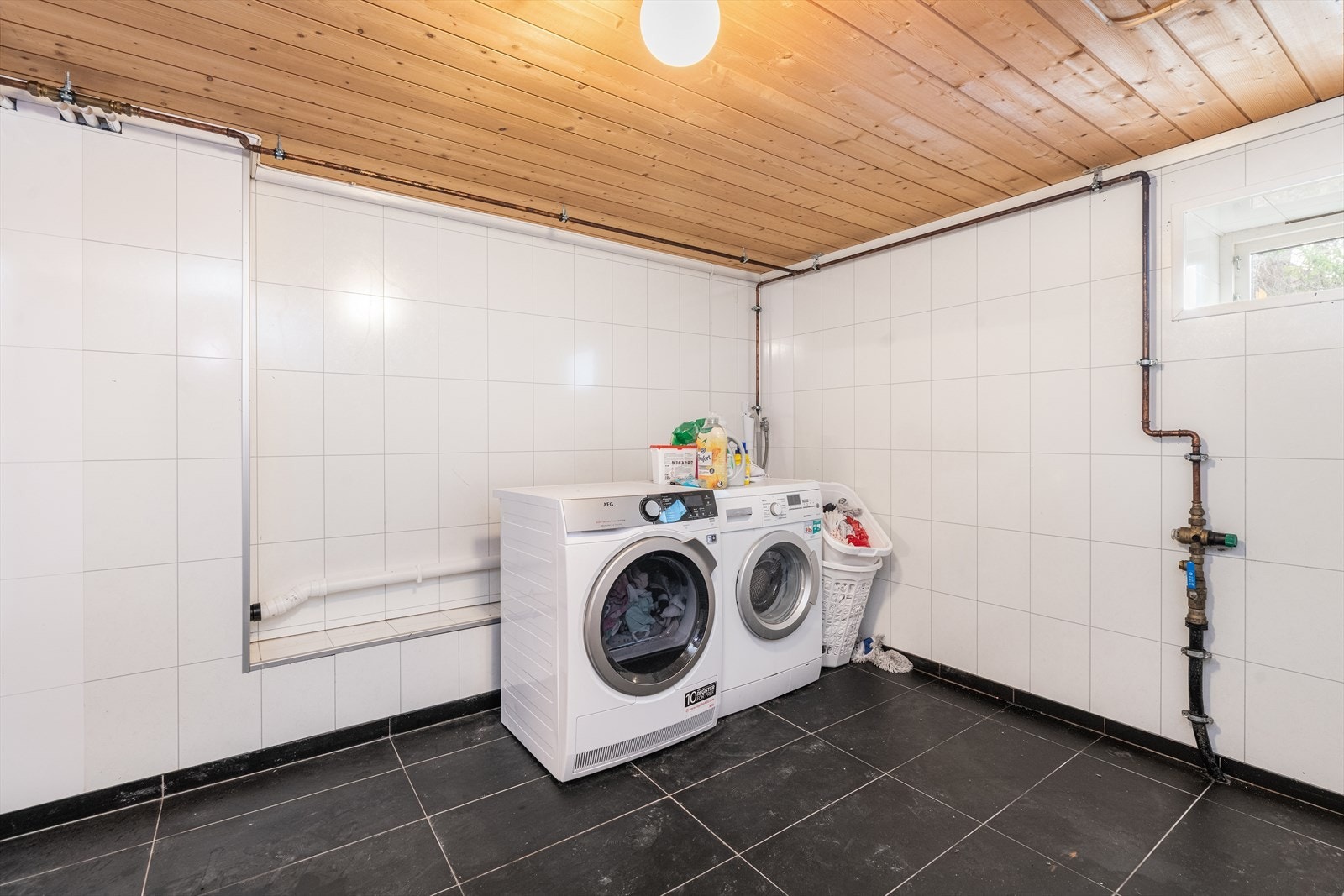 Vaskerommet i kjelleren ble etablert i 2017, med nytt støpt gulv med varmekabler/fliser, veggplater, rør, elektrisk opplegg mm. Arbeider er utført av håndverkerforetak. Vaskerommet er av god størrelse, med opplegg for og plass til vaskemaskin. Galleribilde