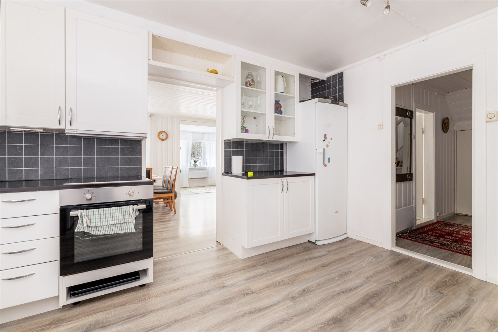 Kjøkkenet har godt med oppbevaringsplass i innredning med takhøye overskap, samt innslag med glass-skap og åpne hyller. Hele rommet samt innredning ble pusset opp/montert i 2017, hvor deler av innredningen er tilpasset/bygget på stedet. Galleribilde