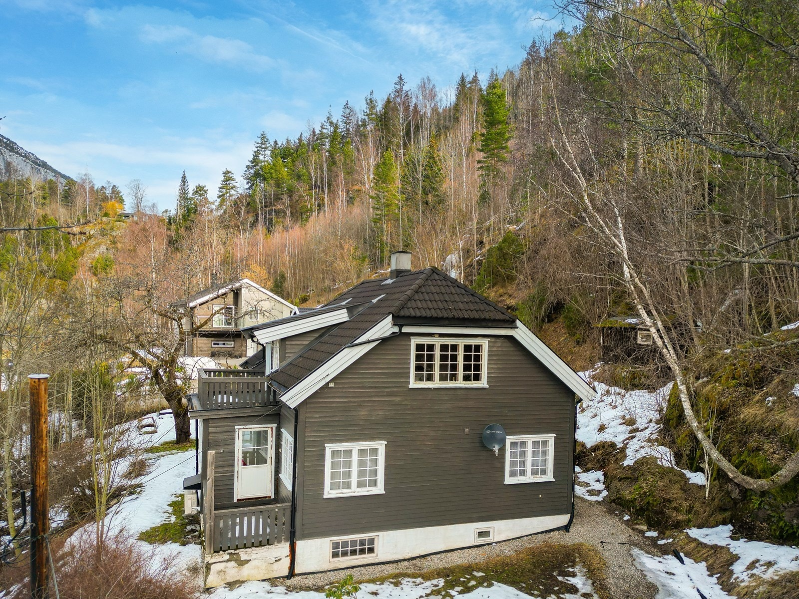 Tomten er opparbeidet med gruset innkjørsel/parkering, plenarealer og noe naturtomt. Ut fra stuen er det adkomst til vestvendt veranda på ca. 5 m2. Ut fra soverom i 2. etasje er det adkomst til lufteveranda på ca. 5 m2. Galleribilde