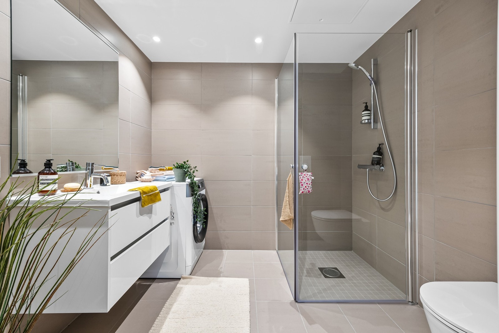 Badet har en prefabrikert løsning med downlights og vannbåren gulvvarme, som gir både komfort og stil. Galleribilde