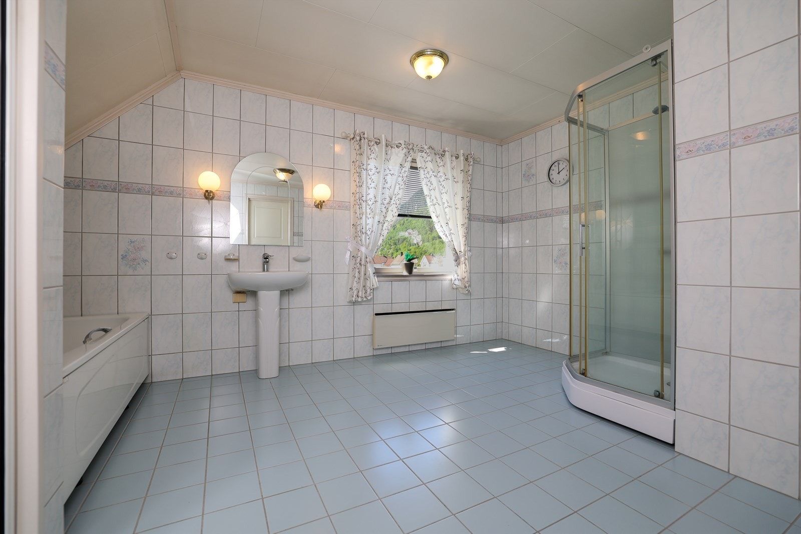 Her er det et stort bad som er utstyrt med både badekar og dusjkabinett Galleribilde