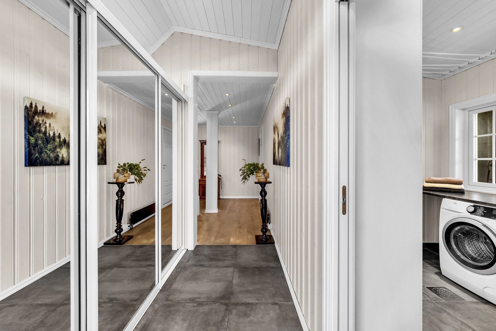 Du ønskes velkommen inn i en flislagt og lysmalt entré med stor skyvedørsgarderobe for praktisk oppbevaring og lagring av sko og annet yttertøy. Galleribilde