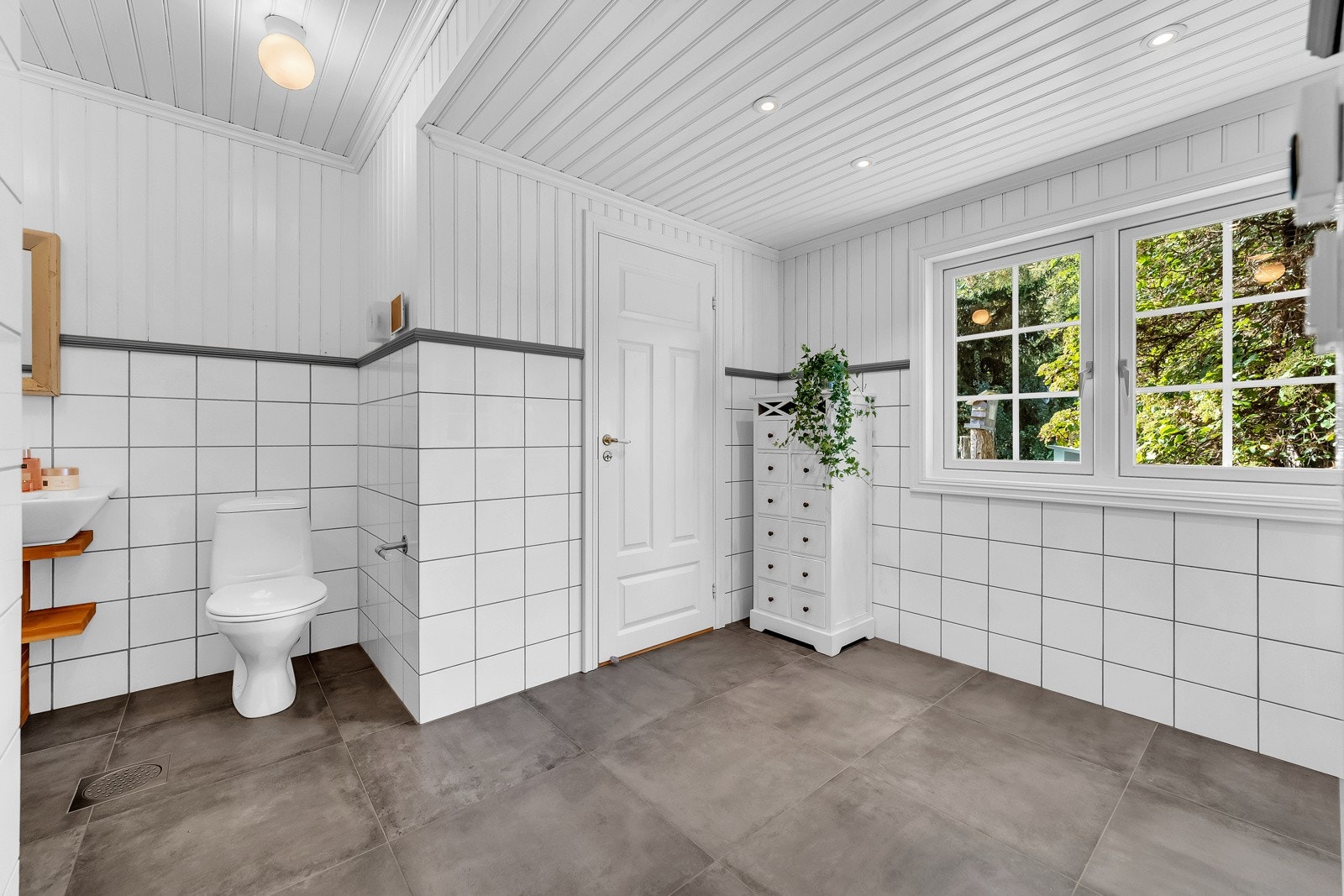 Baderommet er utstyrt med elektrisk gulvvarme, servantskap med servant med ett-greps armatur, gulvstående toalett, bidet, dusjhjørne med innsvingbare glassdører og dusjarmatur tilkoblet hånddusj. Galleribilde