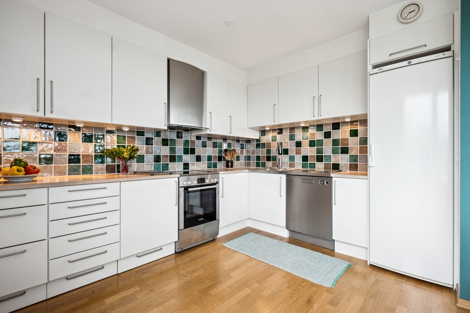 Kjøkkenet har en svært smakfull innredning, med glatte fronter, heltre benkeplate og opplegg for oppvaskmaskin. Galleribilde