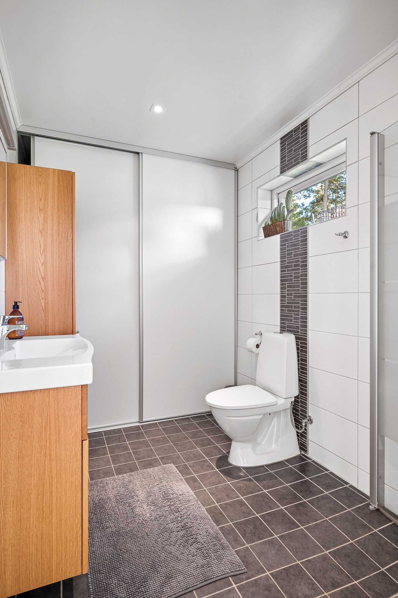 Rymligt badrum med god förvaring vid entré gästhus 1 Galleribilde