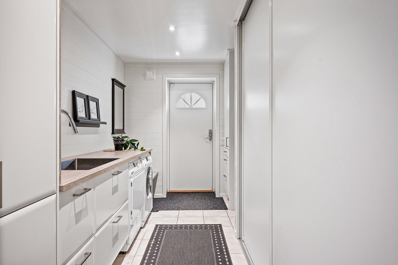 Nedre plan har egen ingång, här finns tvättstuga med mycket bra förvaringslösningar Galleribilde