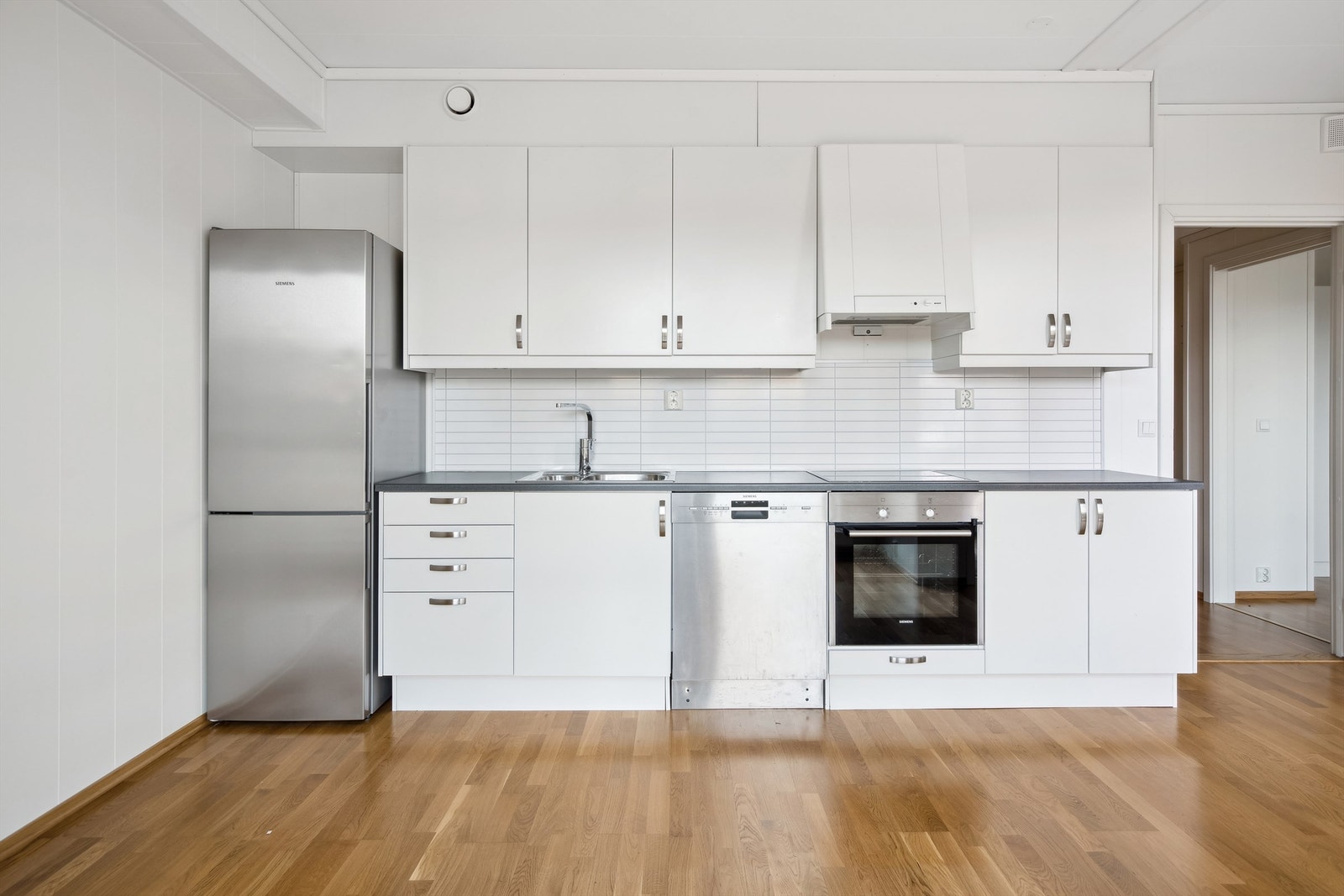 Benkeplaten har en slitesterk, laminert overflate. Mellom kjøkkenbenken og overskapene er det montert kitchenboard. Galleribilde
