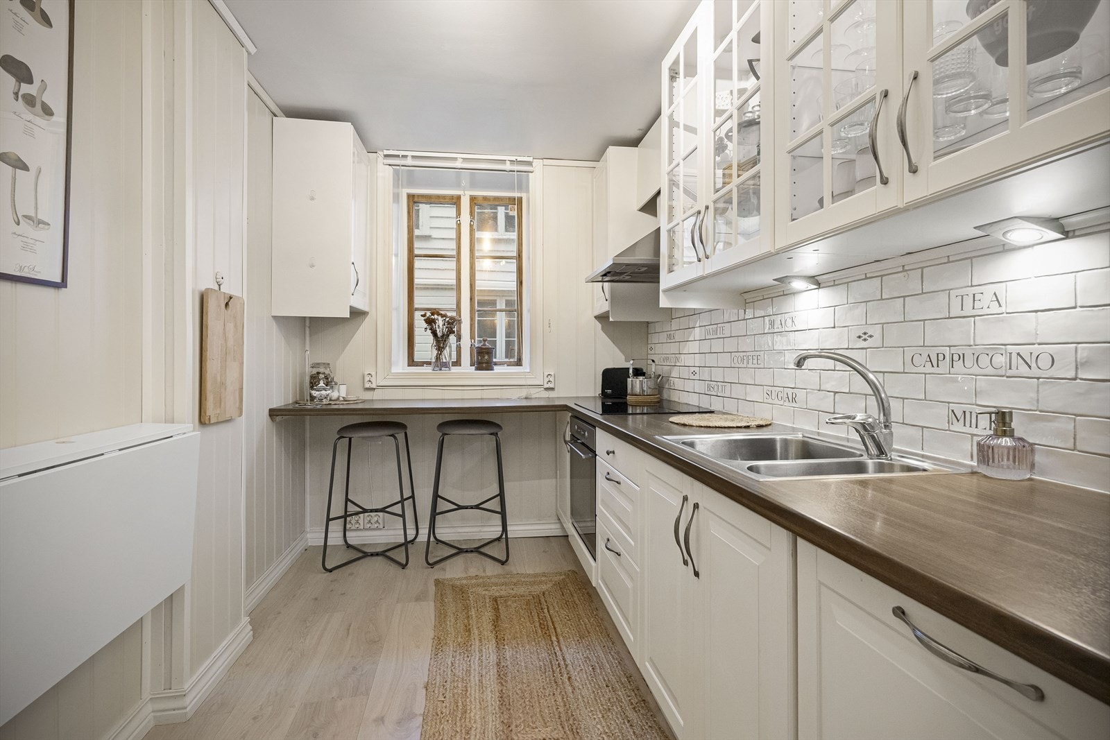 Pent, lyst kjøkken med smart benkløsning Galleribilde