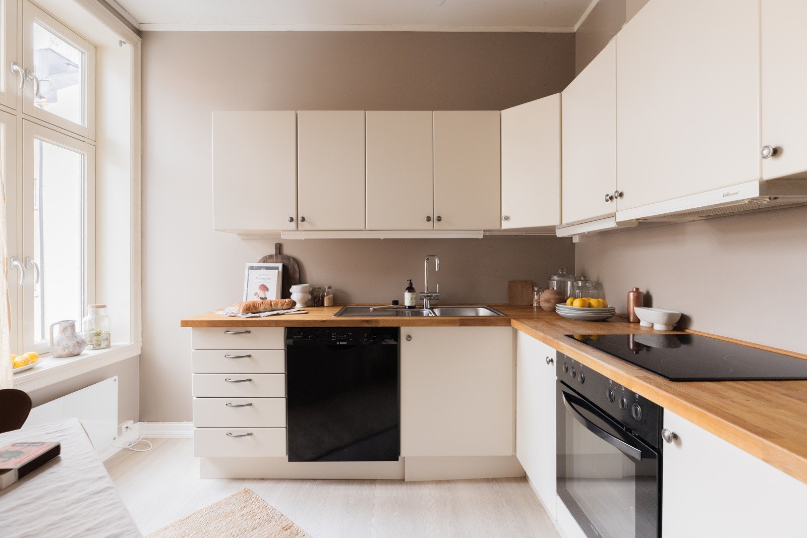 Innredningen som har hvite glatte fronter og lys benkeplate med stålkum Galleribilde