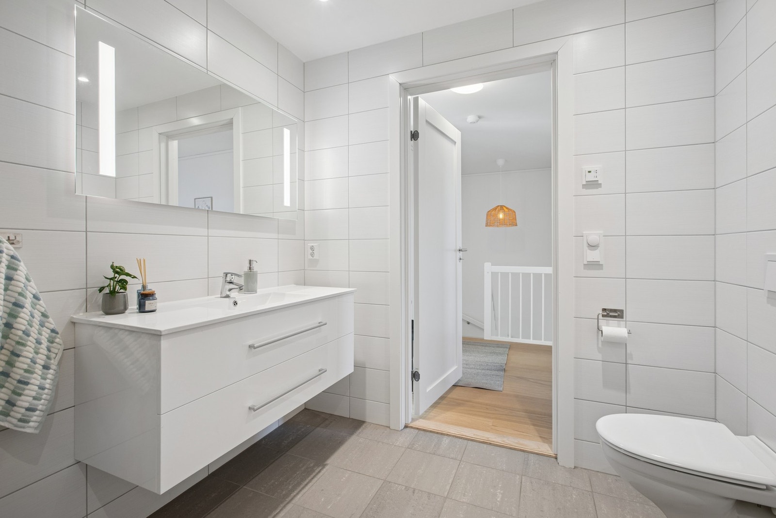 Badet i 2. etasje har et lyst og tidløst uttrykk med flislagte overflater og moderne innredning. Galleribilde