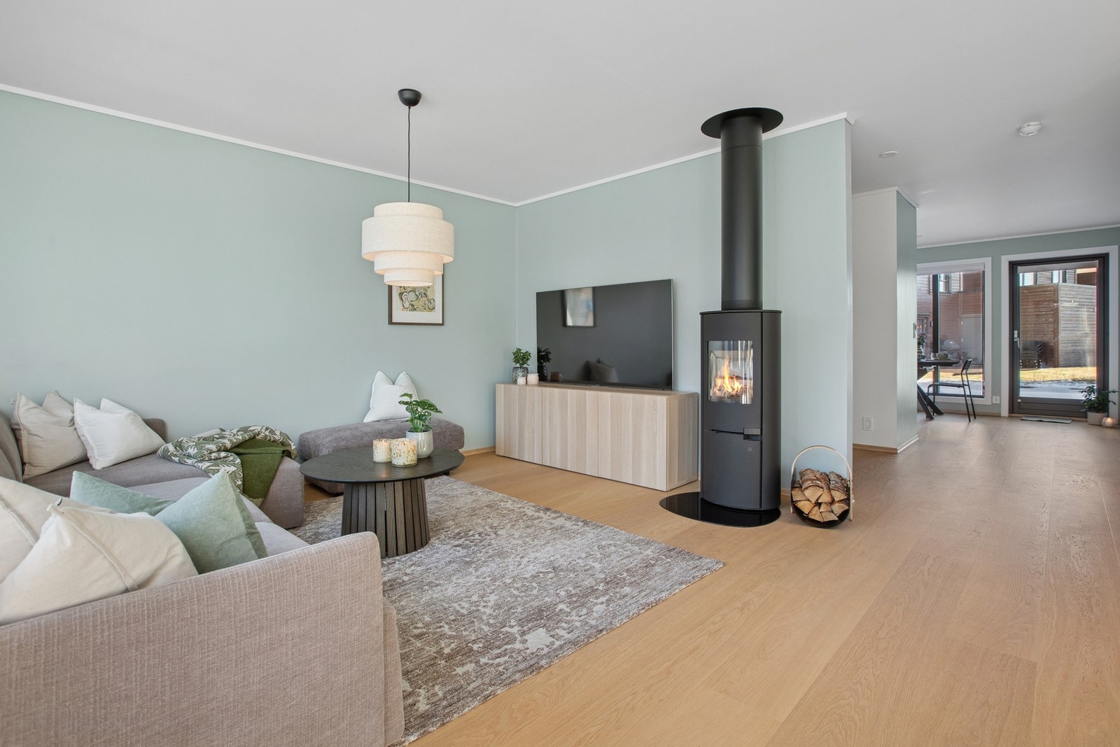 Den romslige stuen har en lun atmosfære, hvor vedovnen skaper både varme og hygge. Galleribilde