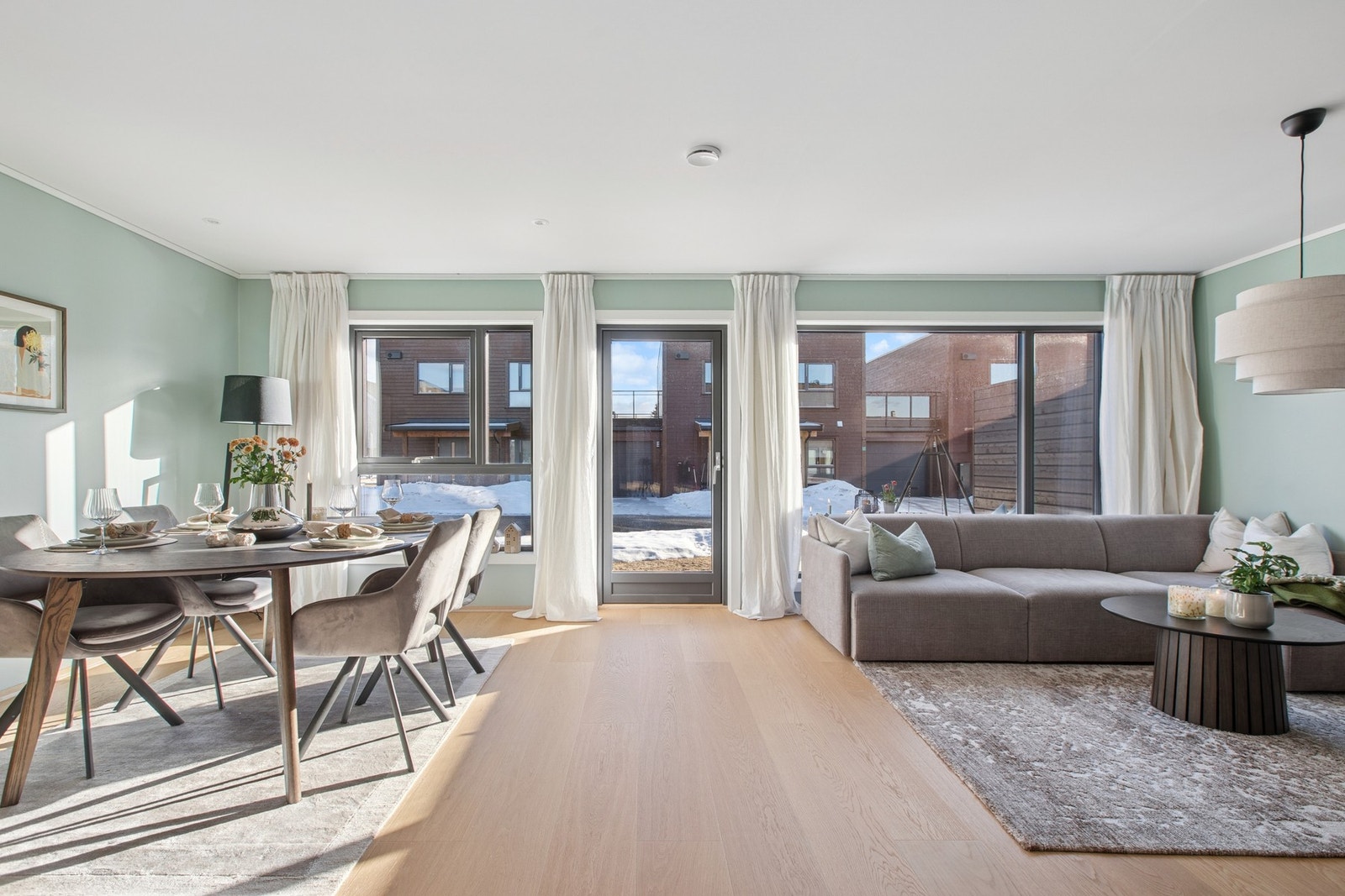 Stuen er lys og innbydende med store vindusflater som slipper inn rikelig med dagslys. Den åpne løsningen gir god plass til både sofakrok og spisebord. Galleribilde