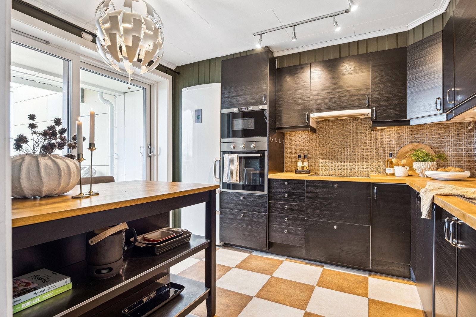 Kjøkkenet er malt i moderne og tidløse farger, med rikelig skap- og benkeplass for god funksjonalitet. Galleribilde