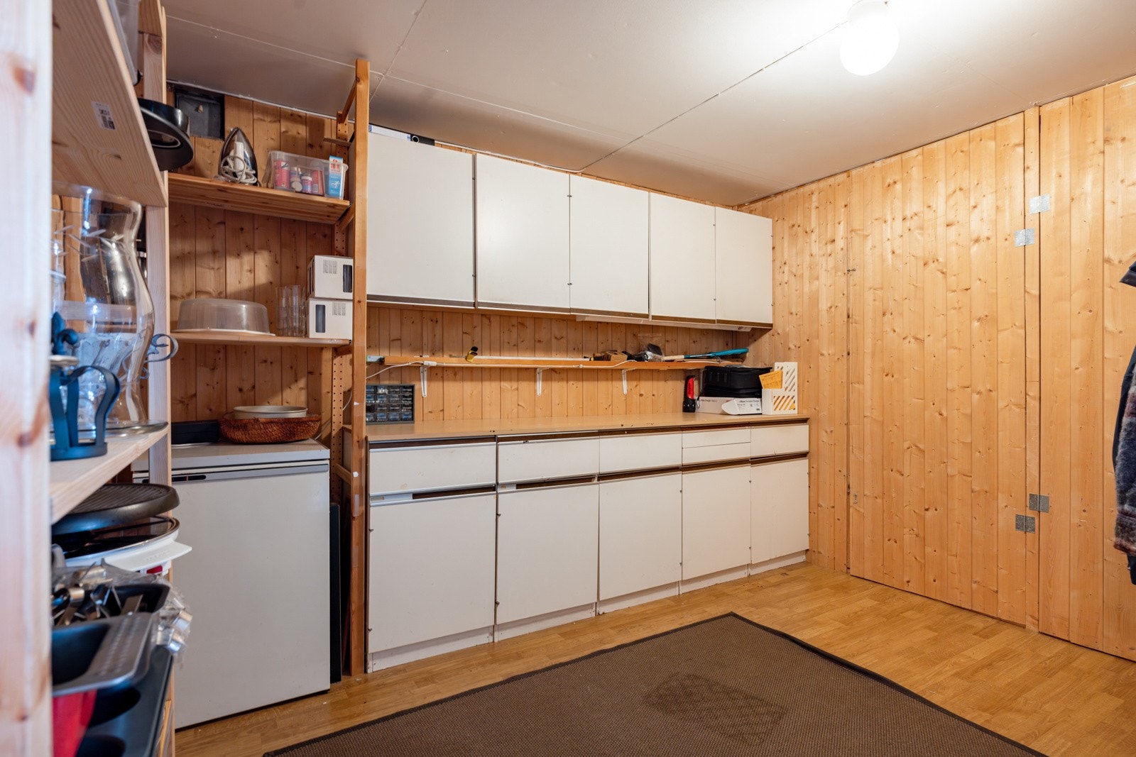 Arbeidsbenk og stor safe i den ene boden. Galleribilde