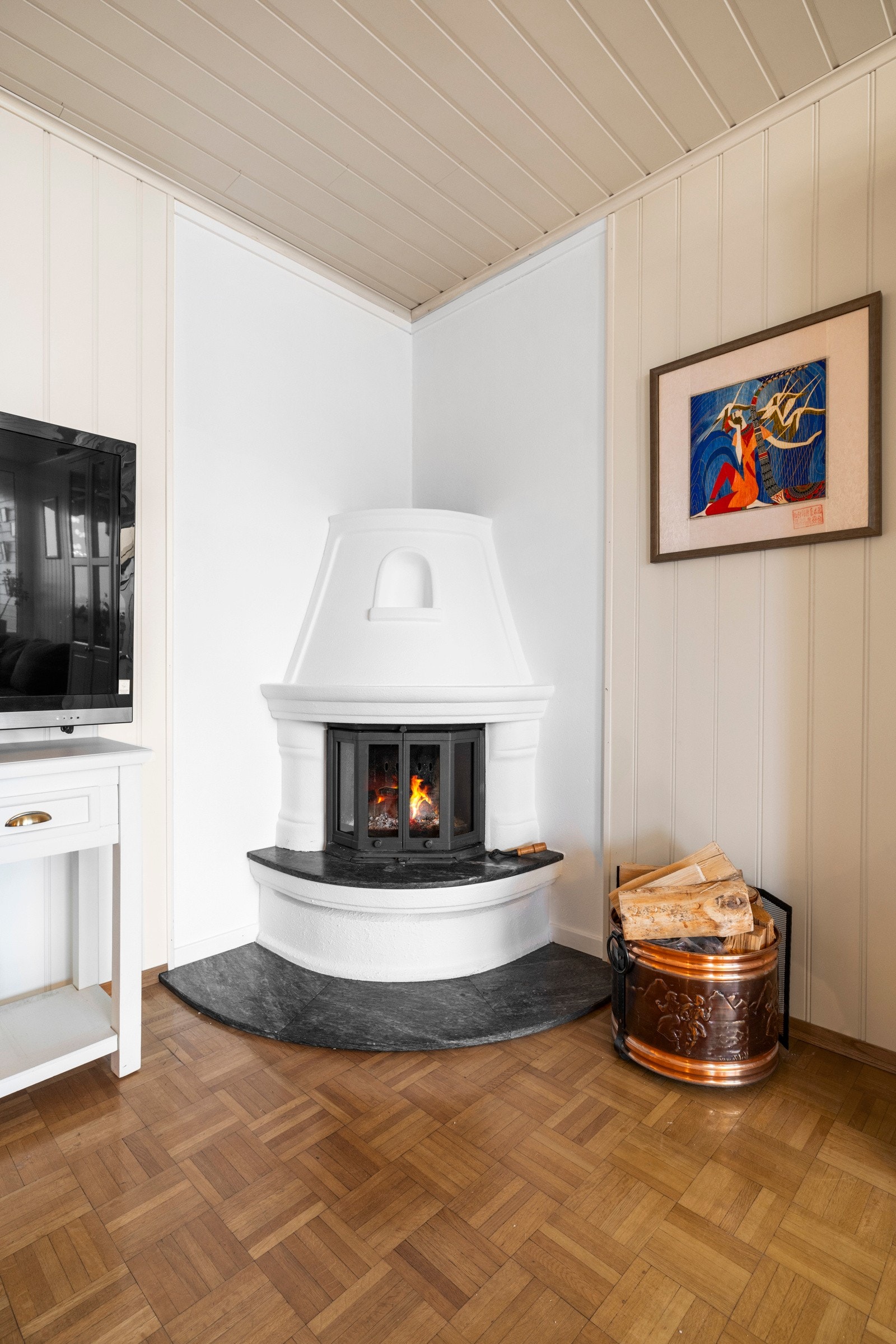 Stuen har en lun peis i hjørnet som bidrar til både varme og hygge på kjølige dager Galleribilde