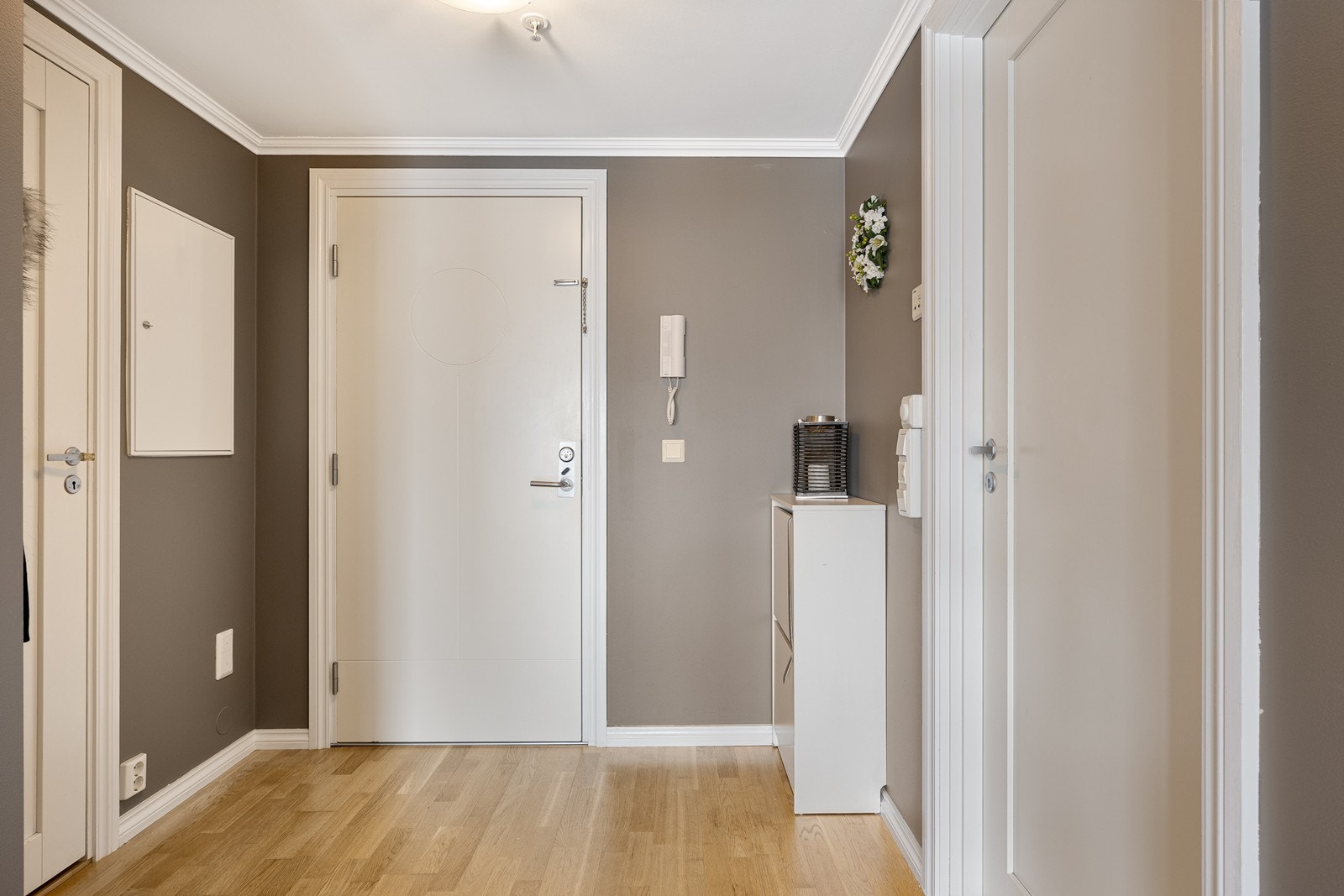 Entréen har gråmalte vegger, og herfra har du direkte adkomst til innvendig bod/garderoberom, badet og videre inn i stuen Galleribilde