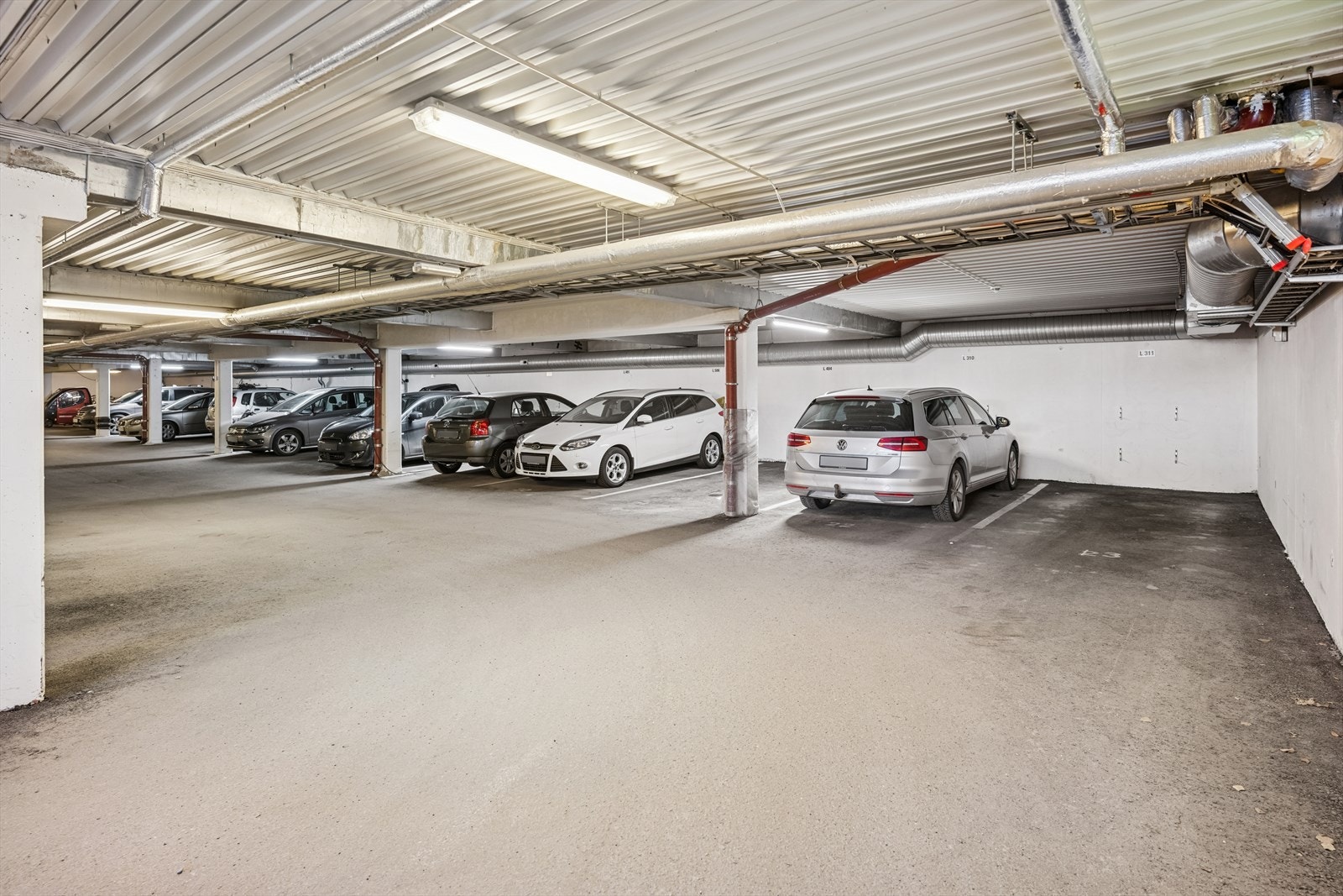 Med leiligheten følger det også garasjeplass med mulighet for å montere elbillader. Medfølgende p-plass er til høyre i bildet Galleribilde
