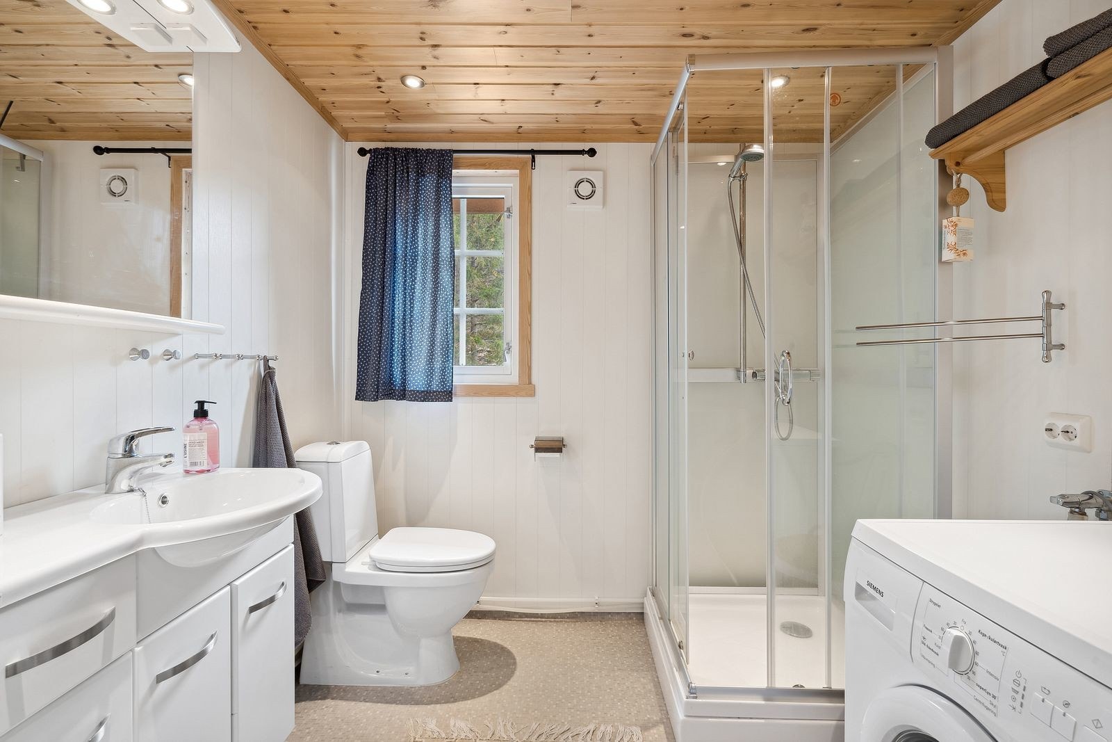 Lyst og fint baderom med opplegg for vaskemaskin Galleribilde