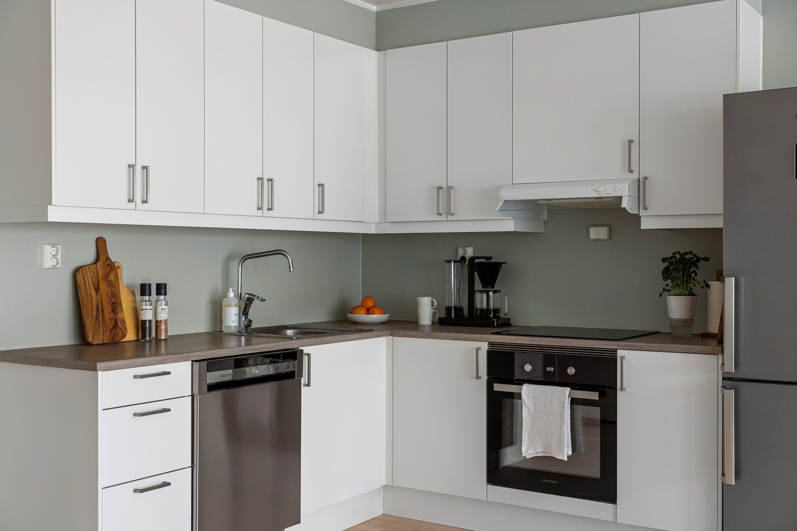 Lys og tidsriktig Sigdal kjøkkeninnredning med integrert stekeovn og induksjon platetopp. Galleribilde