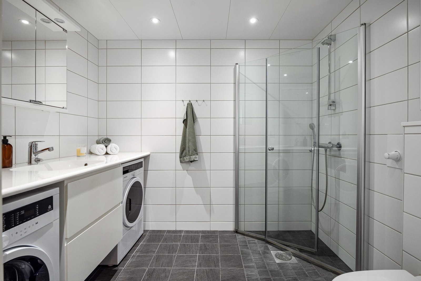 Stort og lekkert bad med flislagte overflater og gulvvarme. Galleribilde