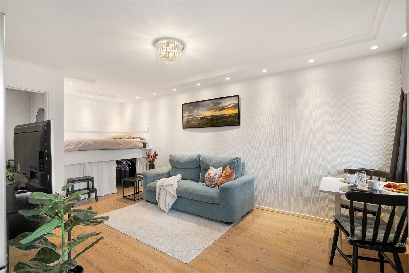 Stuen kan enkelt deles inn i flere soner med mesanin, sofa og spisebord Galleribilde