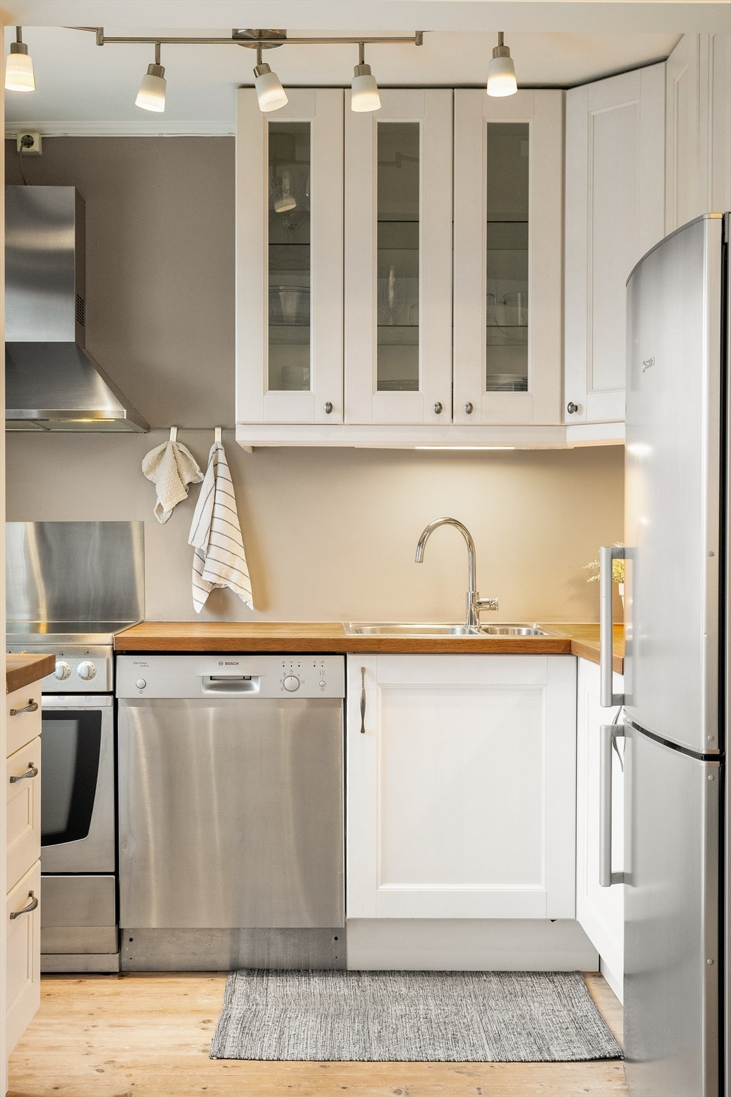 Kjøkkeninnredning med glatte laminerte fronter, heltre benkeplate med nedsenket oppvaskkum Galleribilde