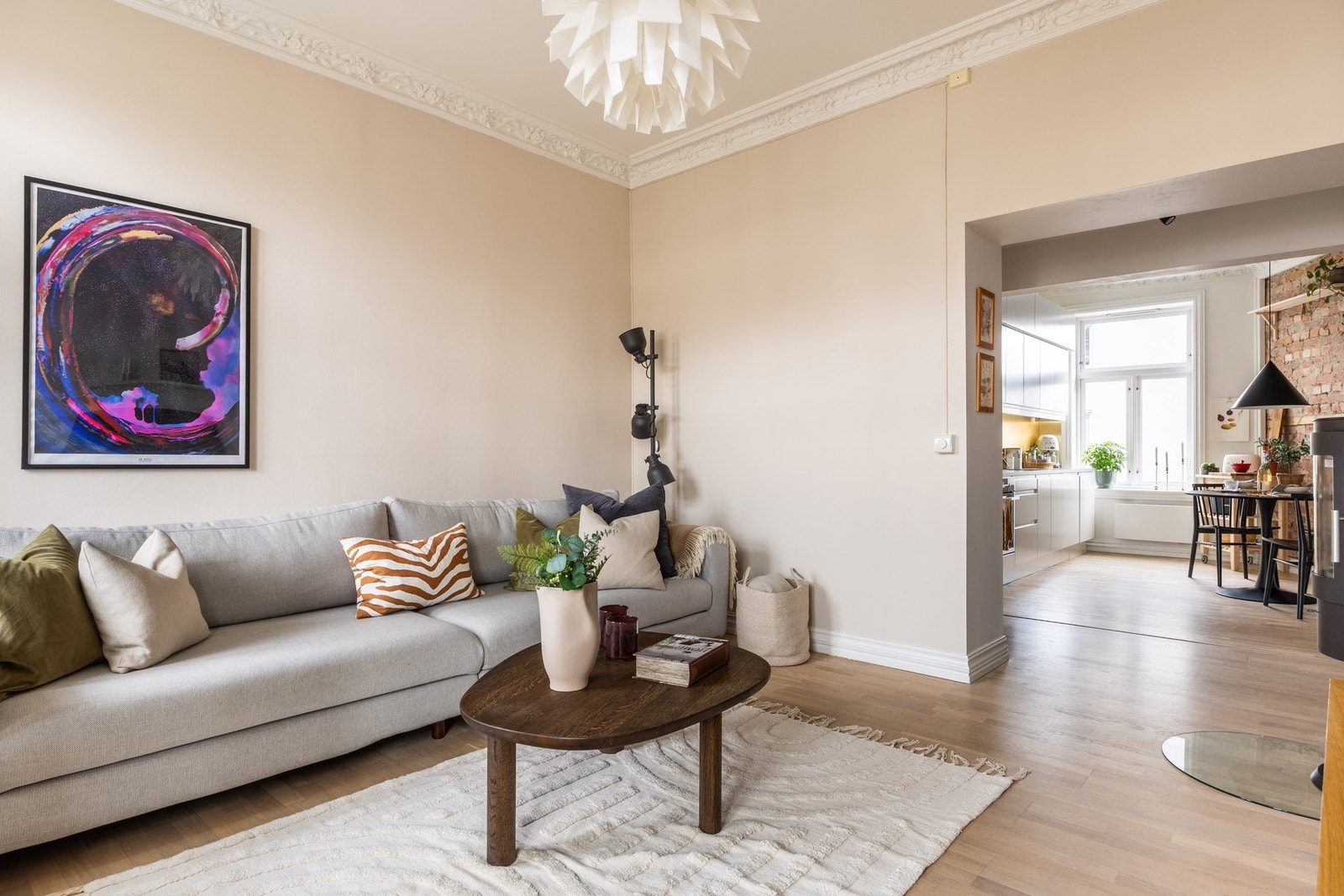 Delvis åpen stue- og kjøkkenløsning. Leiligheten har en lun og luftig atmosfære. Galleribilde