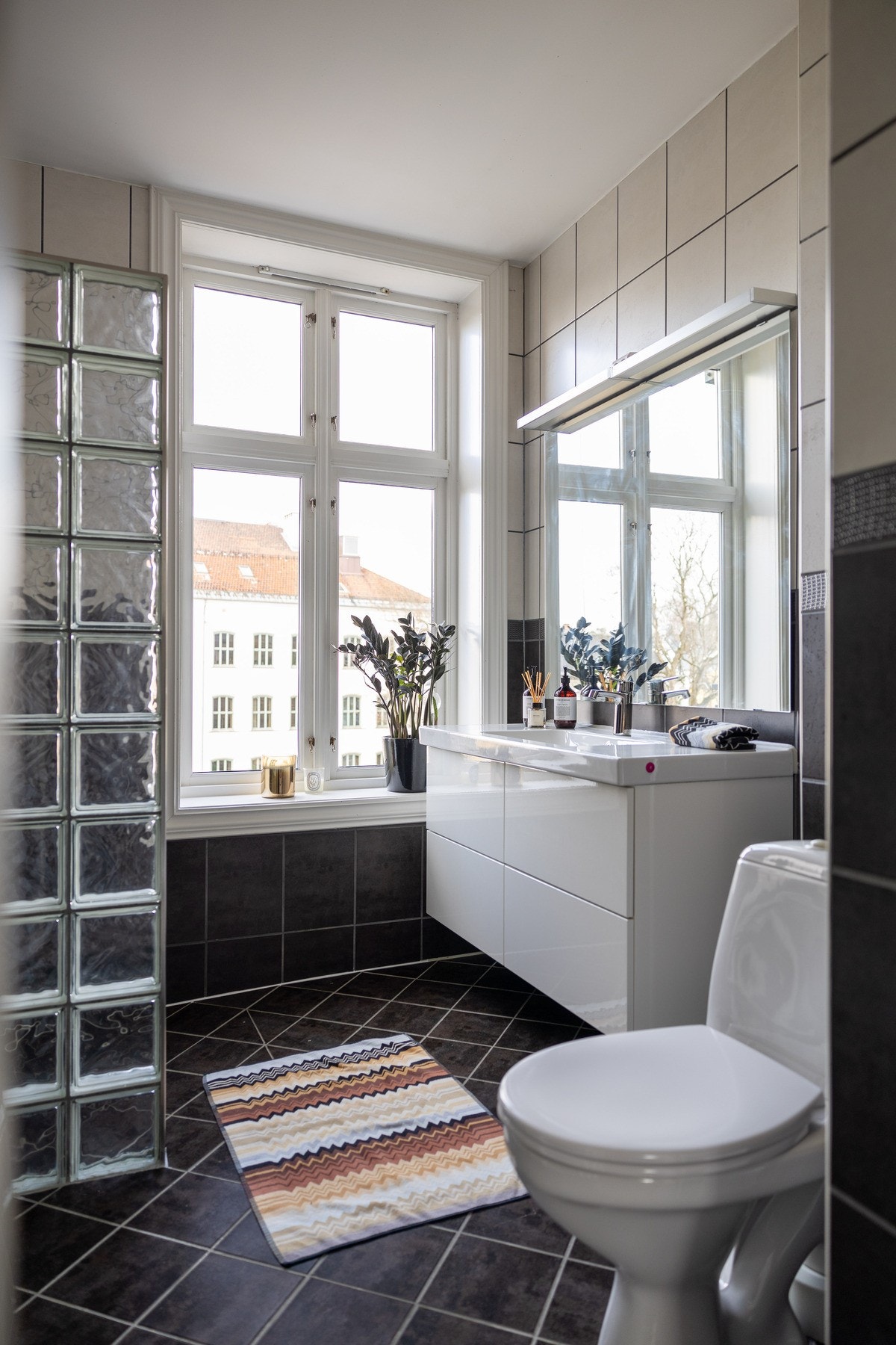 Dusjhjørne med glassbyggerstein, toalett og heldekkende servantinnredning fra 2017. Galleribilde