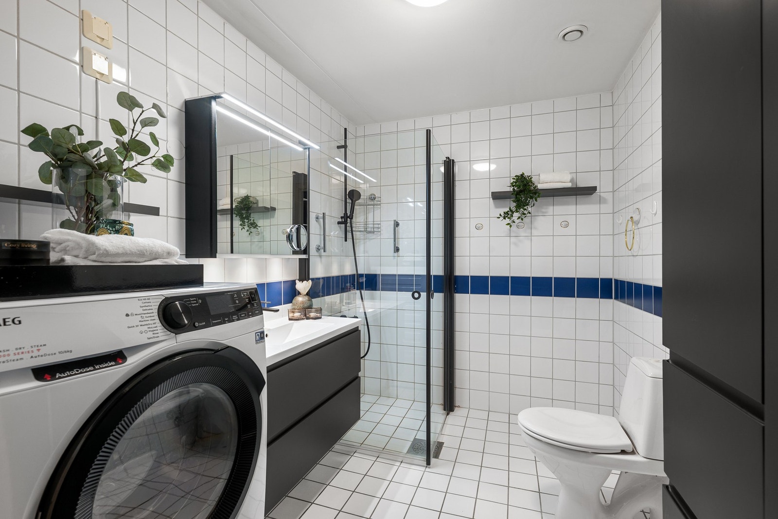 Klassisk, flislagt bad med gulvvarme med opplegg for vaskemaskin. Galleribilde