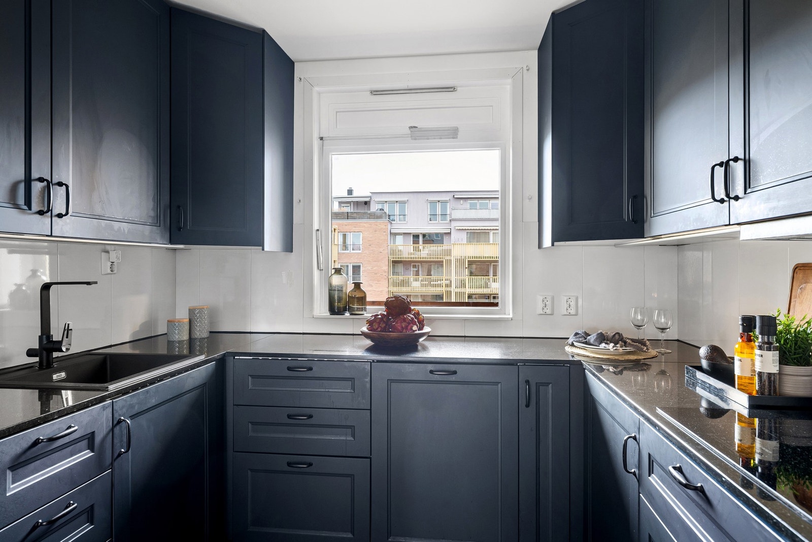 Flott, sosialt kjøkken fra ukjent årstall med profilerte fronter og benkeplate av stein, samt nedfelt oppvaskkum med ett-greps armatur. Galleribilde