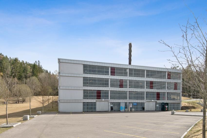 Borettslagets parkeringshus med gjesteparkering utenfor. Det er gode muligheter for leie av parkeringsplass både inne og ute. Pr i dag opplyses det at det er ledige plasser. Galleribilde