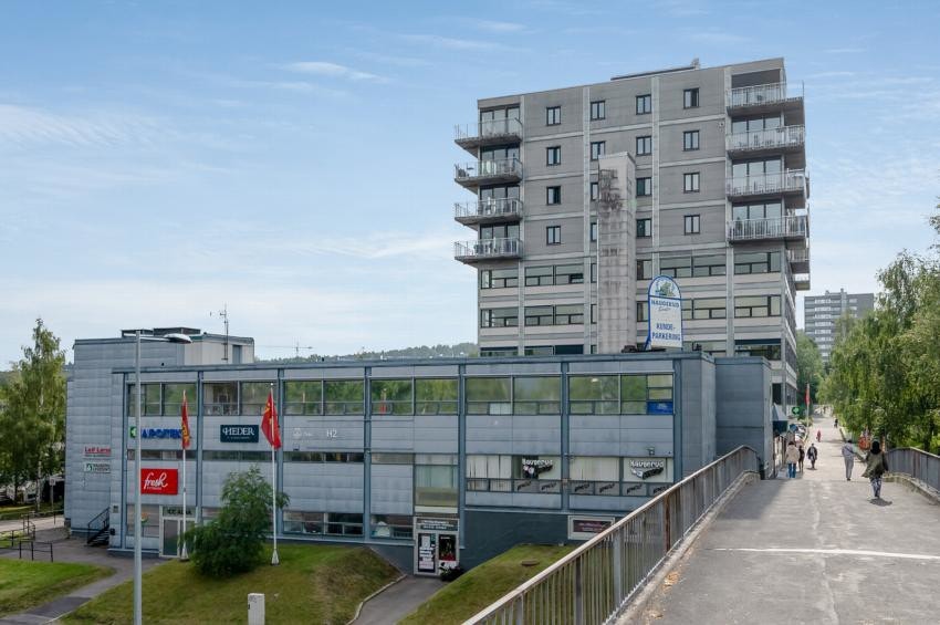 Haugerud senter med blant annet coop extra og fresh fitness. Fotografen står på gangbroen over til T-bane og buss på Haugerud. Man kan skimte borettslaget i bakgrunnen. Galleribilde