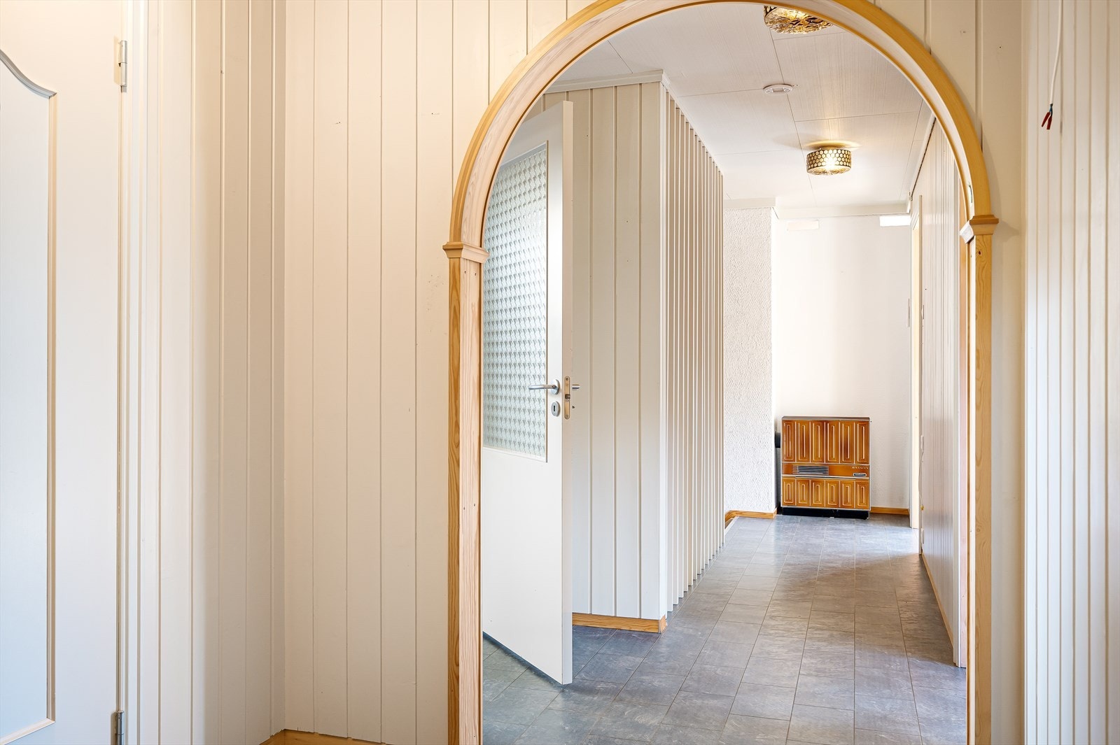 Lys og innbydende entré med buet døråpning. Galleribilde