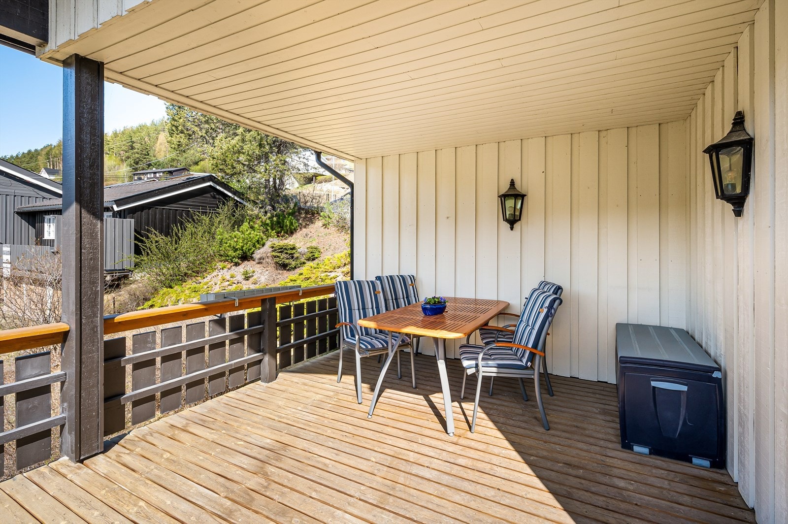 Romslig, overbygd terrasse med plass til utemøbler, ideell for sosiale sammenkomster i et fredelig nabolag. Galleribilde