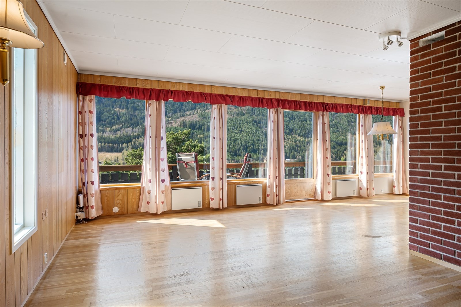 Romslig stue med masse naturlig lys og direkte utgang til en stor terrasse hvor man kan nyte utsikten . Galleribilde