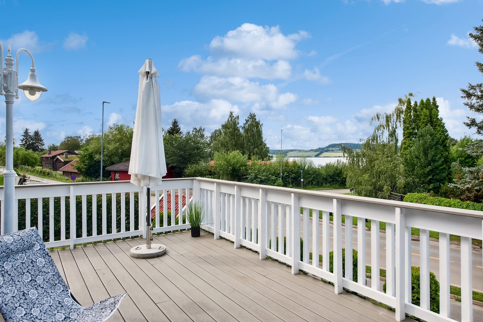 Solrik terrasse utenfor stuen med mjøsutsikt og utsyn mot de historiske bygningene på Domkirkeodden. Galleribilde