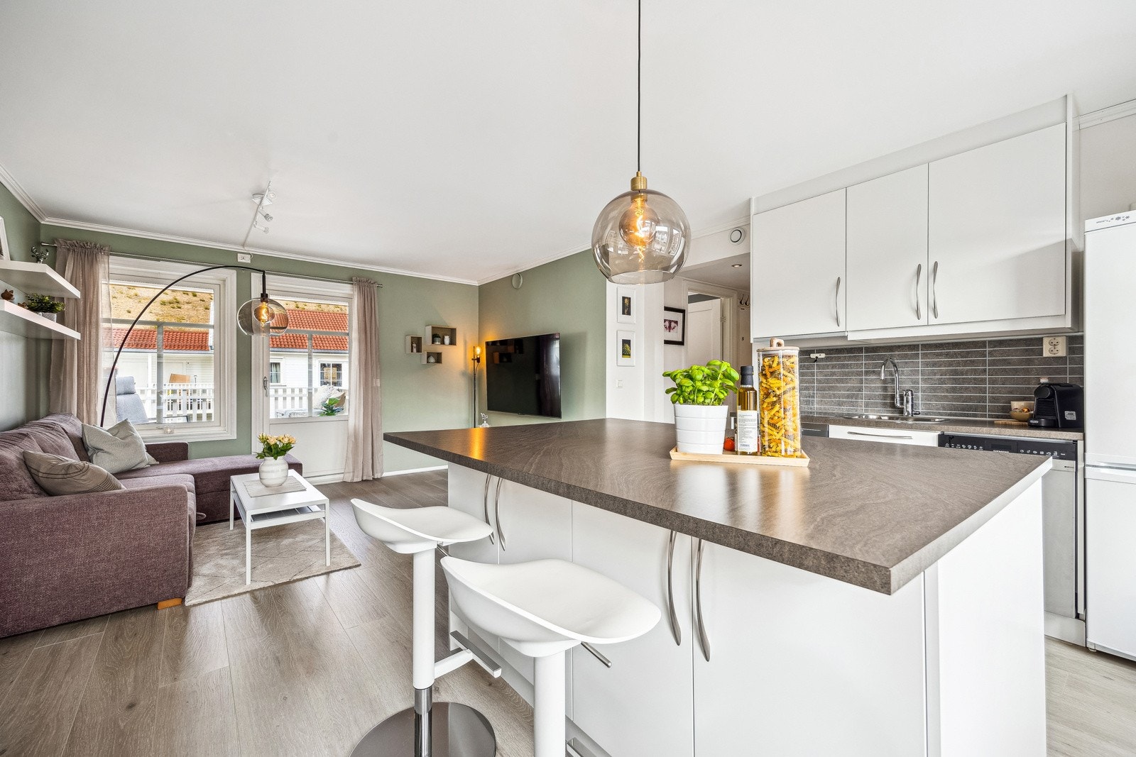 Leiligheten har en romslig kjøkkenøy som gir ekstra benkeplass og fungerer som et naturlig samlingspunkt i rommet. Galleribilde