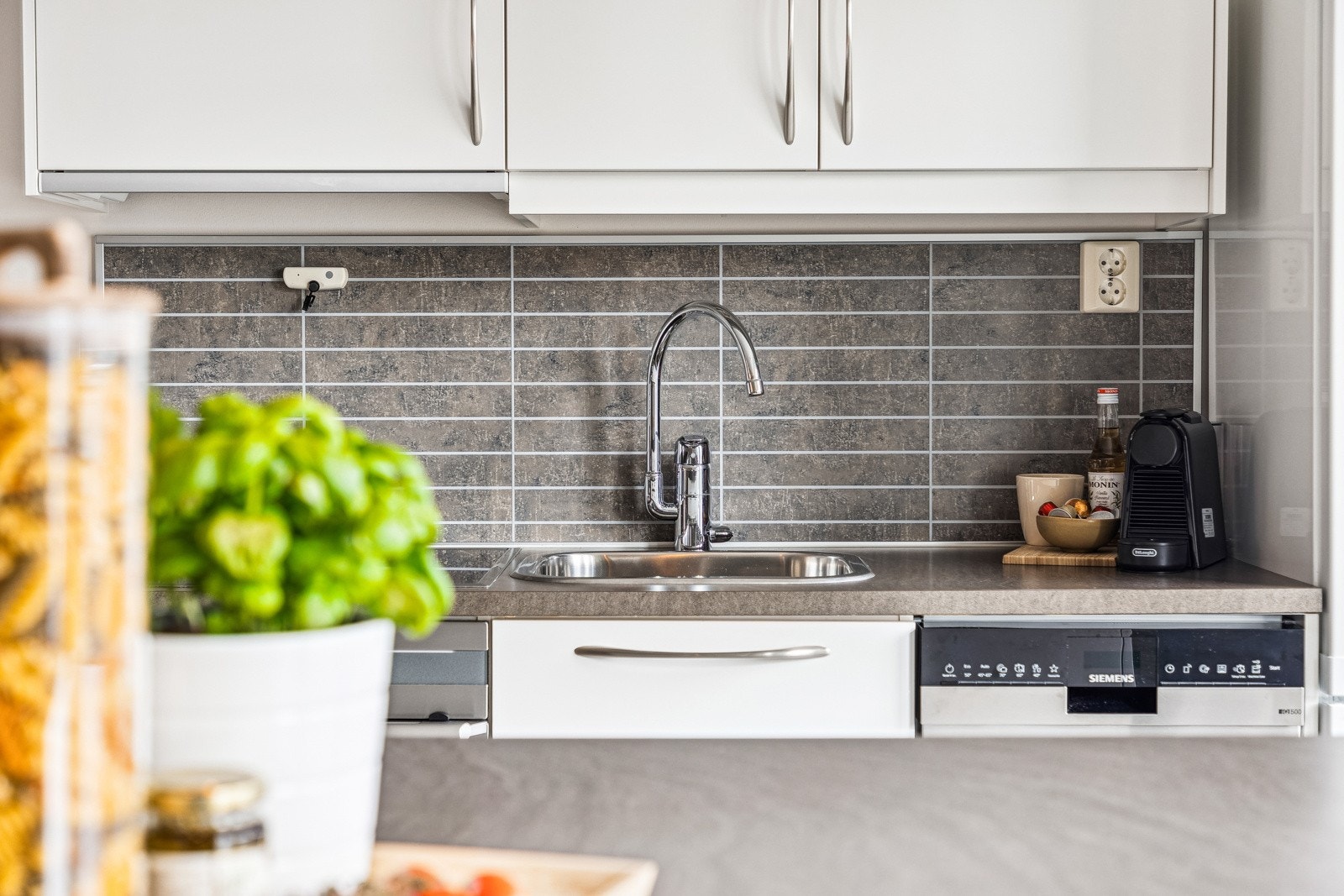 Kjøkkeninnredning fra Norema med glatte fronter og benkeplate av laminat. Galleribilde