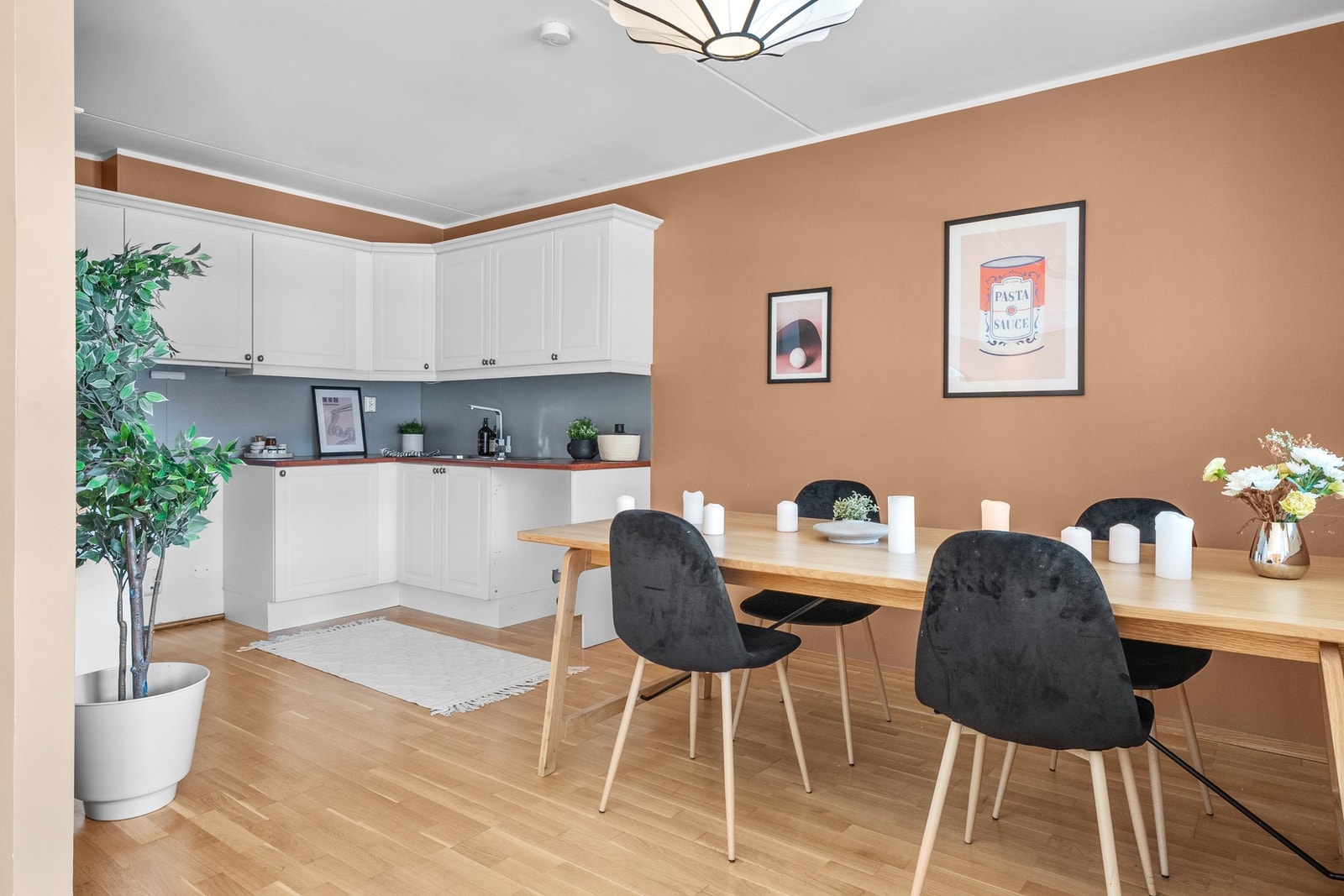 Det delvis adskilte kjøkkenet har en lys innredning med hvite, slette fronter og en praktisk laminatbenkeplate. Galleribilde