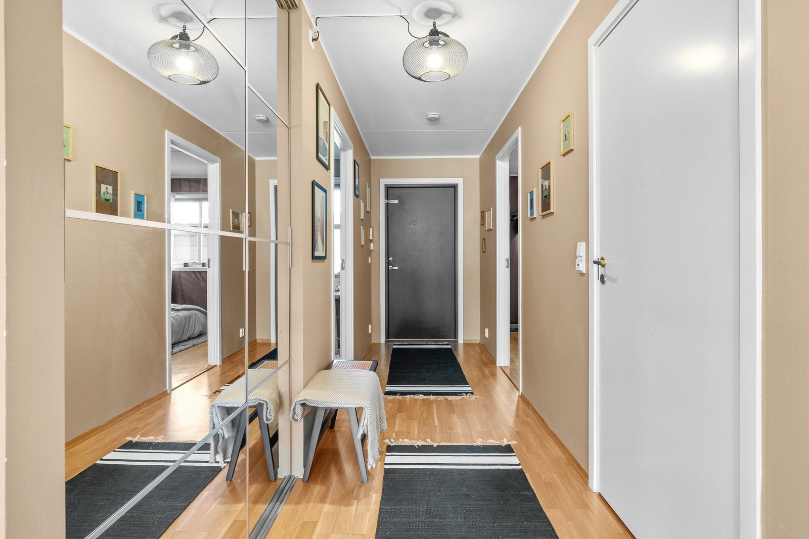 Velkommen inn til en innbydende entré med parkett på gulvet. Her er det god plass til en liten sitteplass og knagger Galleribilde