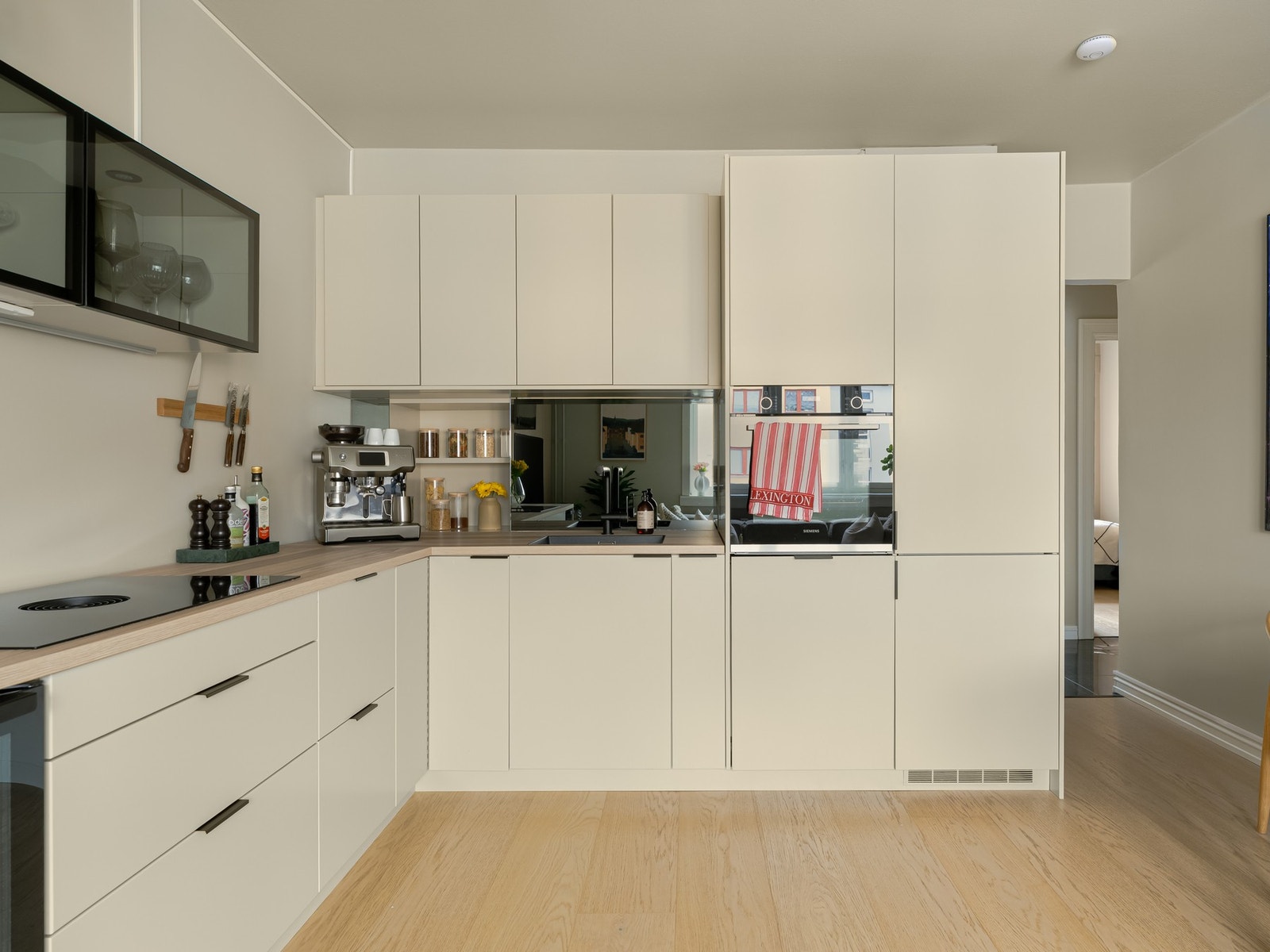 Kombinasjonen av god skap- og benkeplass gir fine lagringsmuligheter i tillegg til arbeidsplass. Innredningen består av beige, slette fronter med soft-close skuffer og skap. Galleribilde