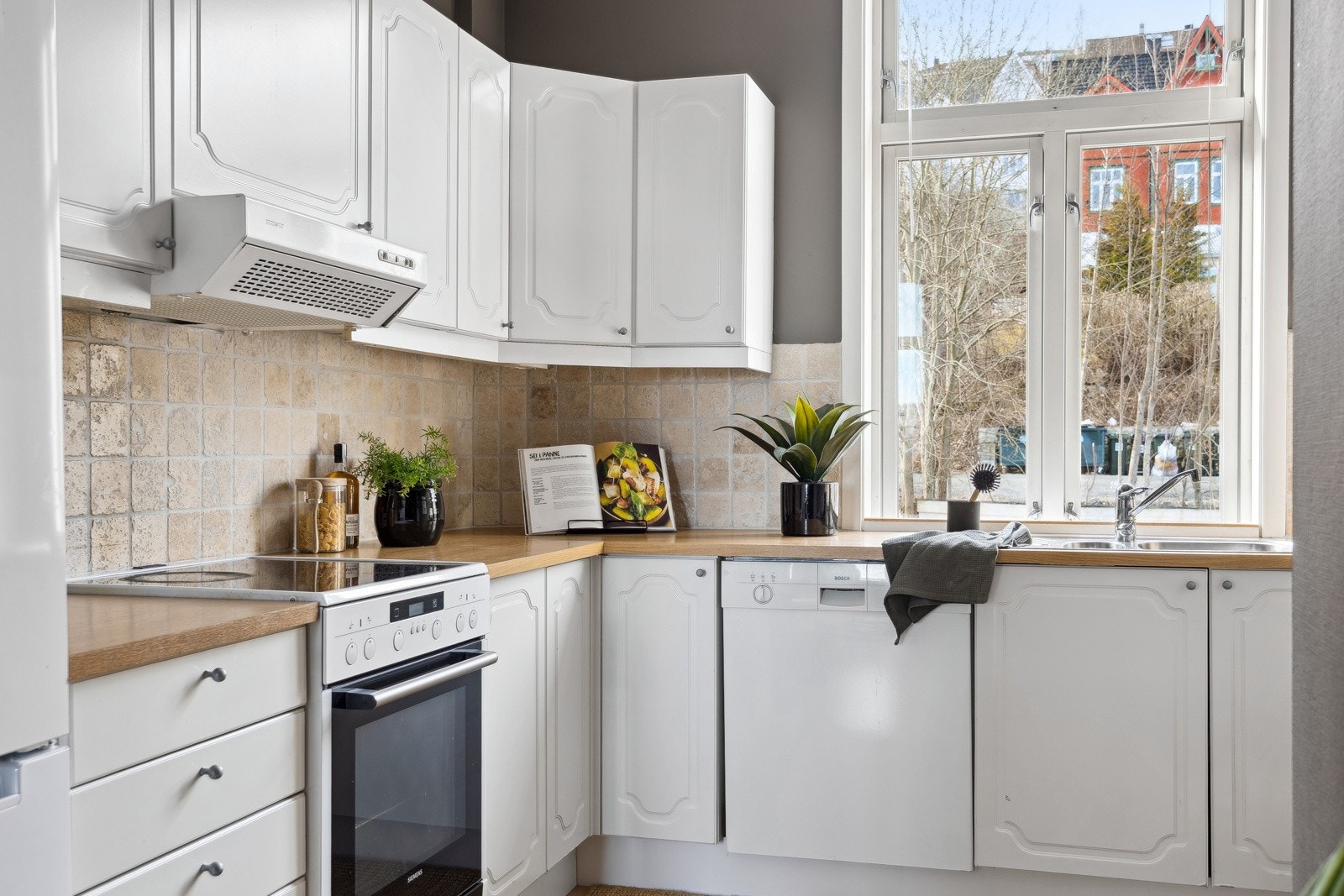 Lyst kjøkken med glatte fronter og benkeplate av laminat. Galleribilde