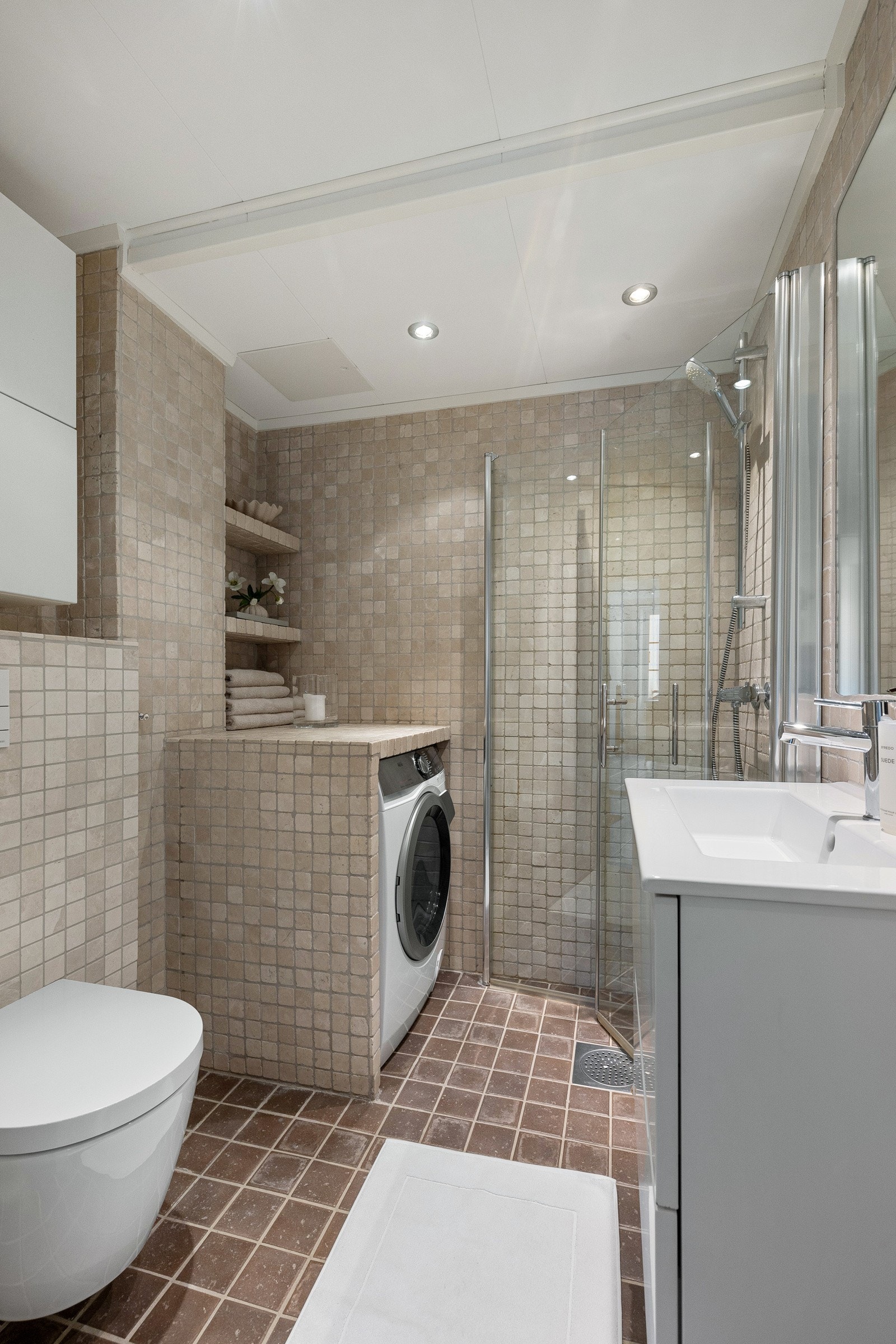 Lekkert og funksjonelt bad med fliser på vegger og gulv samt malte plater i taket. Galleribilde