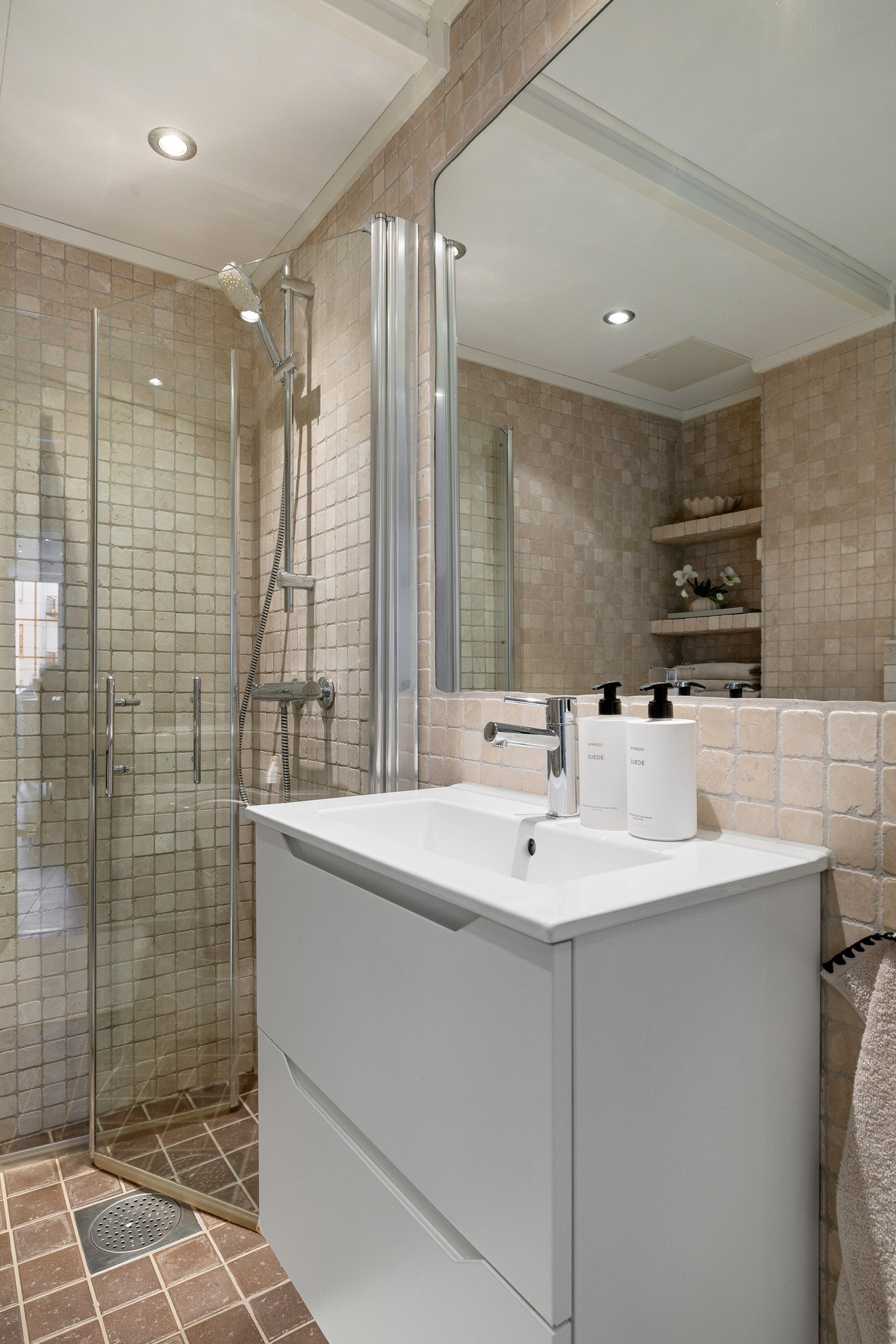 Rommet er praktisk innredet med dusjhjørne, servant med underskap, vegghengt toalett og opplegg for vaskemaskin. Galleribilde