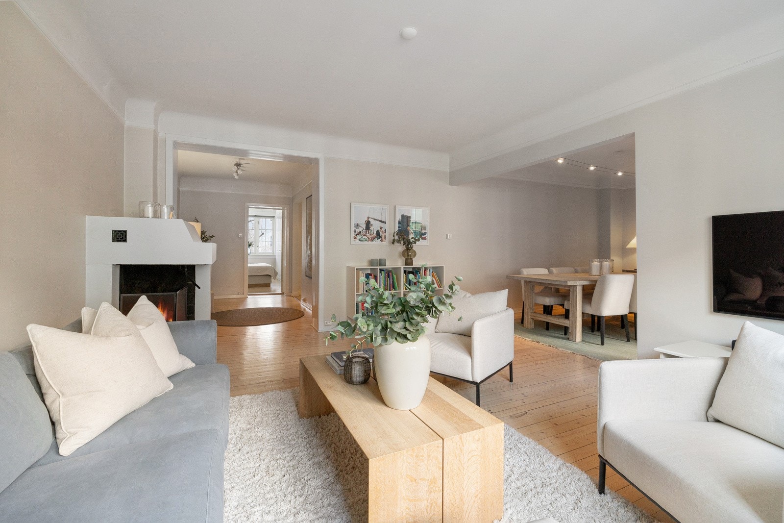 Rommet er smart utformet med en naturlig inndeling mellom sofahjørne og spisestue, noe som gjør det ideelt for både avslapning og sosiale sammenkomster. Galleribilde