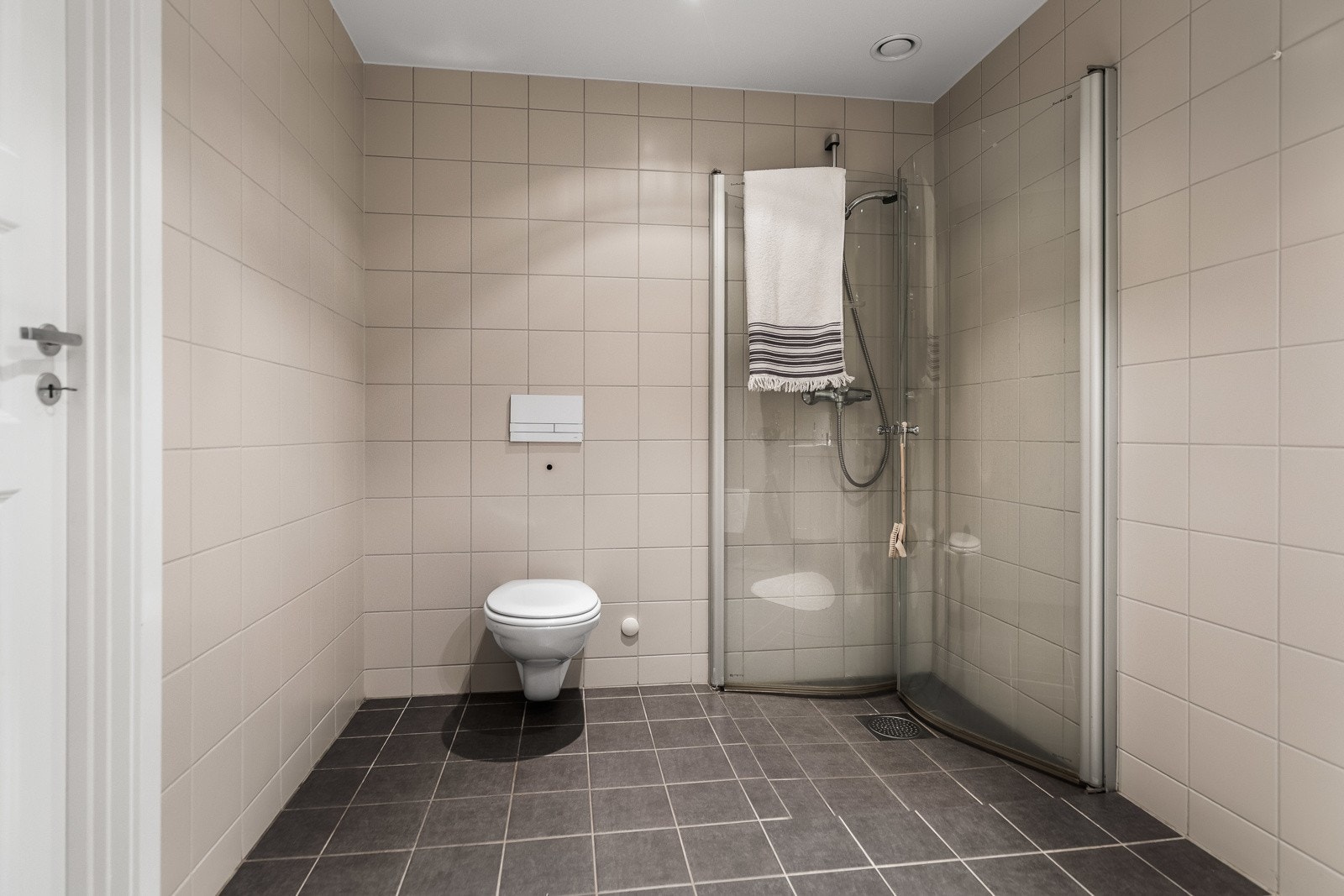 Leiligheten har et pent bad som er utstyrt med dusjhjørne og veggmontert toalett. Galleribilde